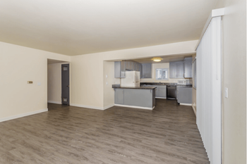 a living room and kitchen with a wood floor and white walls at Gateway, Chico, CA 95926